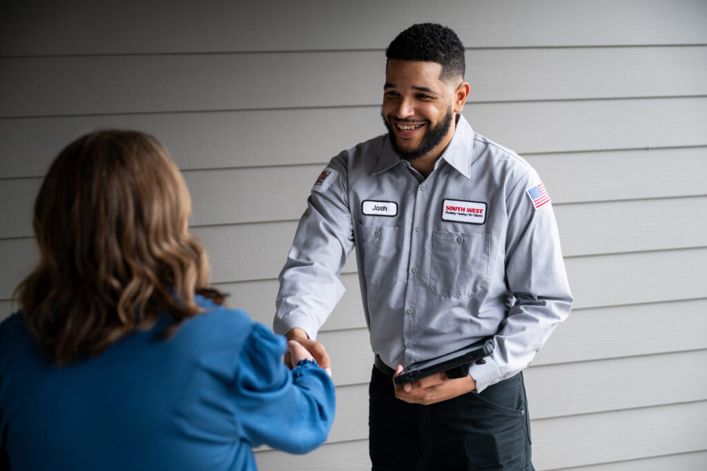 Plumber shaking hands with customer.