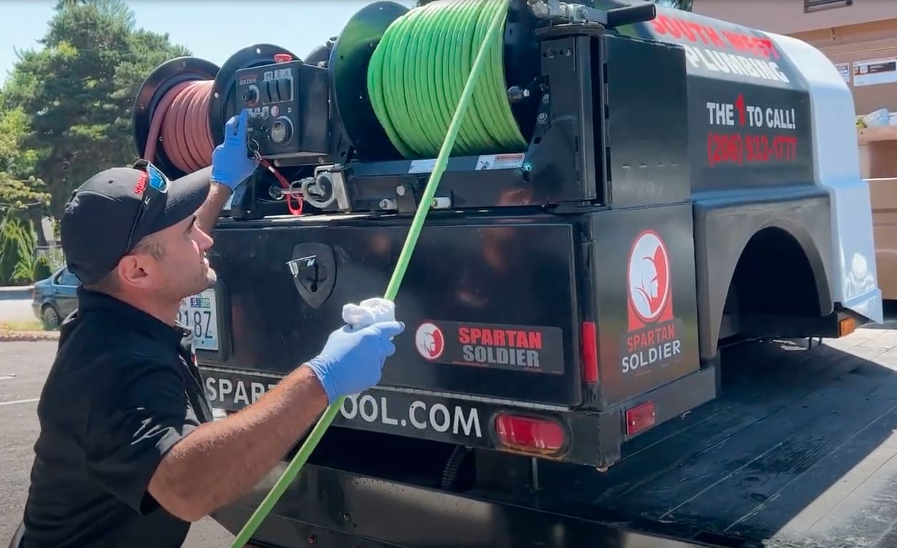 Technician pulling green cord on a hydro jetting machine.